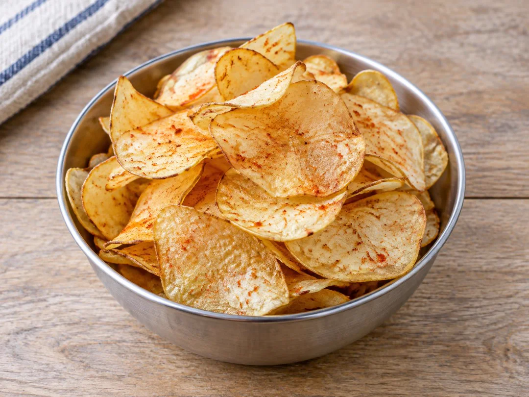 Aloo Chips — Thin pale-golden homemade potato crisps with curled edges and chilli seasoning