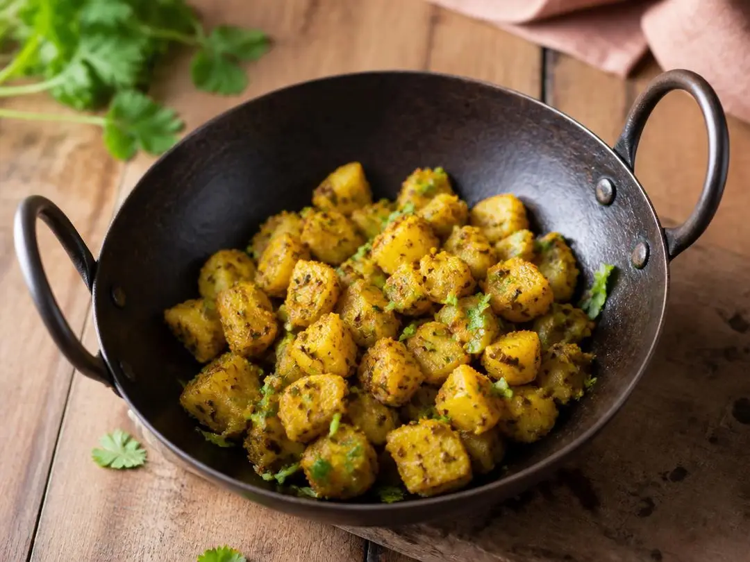 Aloo Jeera — Dry jeera aloo potatoes with cumin seeds in an iron kadai