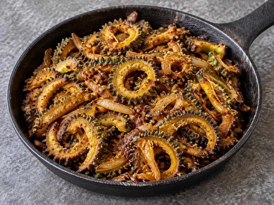 Crisp Karela Fry — Crisp ridged bitter-gourd rings with browned onions and spiced coating