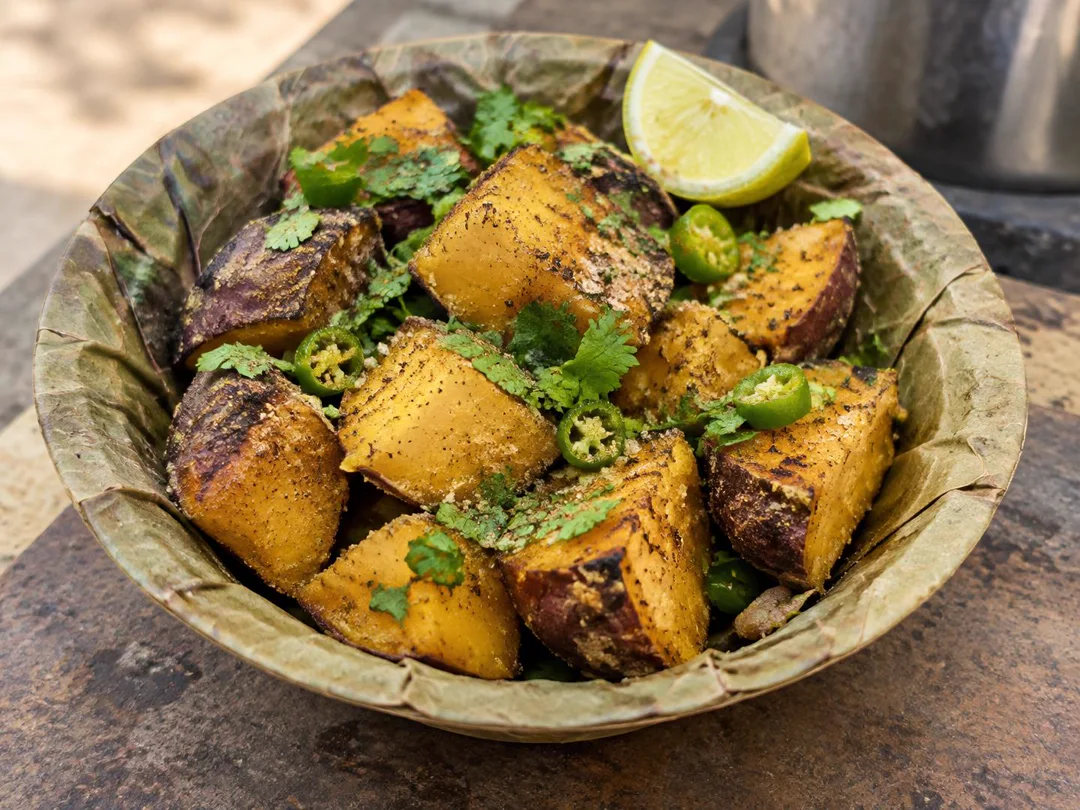 Shakarkandi Chaat — Roasted sweet potato chunks with chaat masala, lemon, coriander and green chilli in a leaf bowl